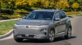 Hyundai Kona Electric - A modern, electric vehicle with a sleek design against a scenic backdrop, showcasing eco-friendly technology and innovation